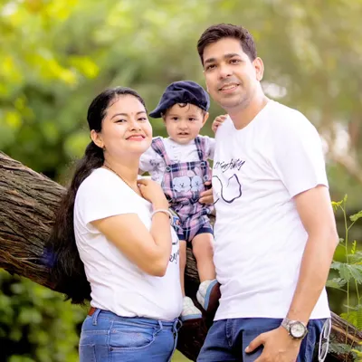 A lovely family of three posing on a tree branch during their outdoor photoshoot. We find unique spots in nature that make for fun and memorable family pictures.