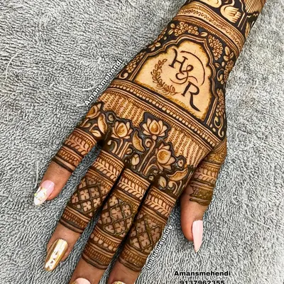 A beautiful back-of-hand design personalized with the couple's initials, "H & R". The monogram is framed by a floral wreath and surrounded by lotus and swan motifs.