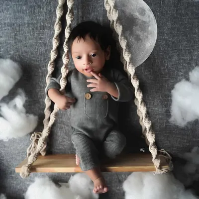 Twinkle, twinkle, little star. This baby boy looks right at home on his swing, set against a night sky with a glowing moon and fluffy clouds.