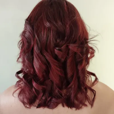 A rich, deep red that’s full of life. We created this custom red shade and styled it with voluminous curls to show off the color's dimension and shine. This is a perfect example of a bold color that is also incredibly sophisticated.