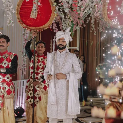 A groom's grand entrance, looking regal in his white sherwani and holding a traditional sword. We capture the groom's moments with the same importance as the bride's.