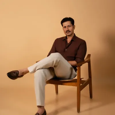 A classic seated portrait of actor Sumeet Vyas for an editorial feature. The clean background and simple chair put all the focus on his confident presence, making it a strong and effective headshot for professional use.