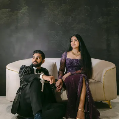 A dramatic and moody portrait of Mariam and Joseph. This styled indoor shoot with a forest backdrop creates a cinematic, fairytale atmosphere, highlighting their elegant attire and unique chemistry.