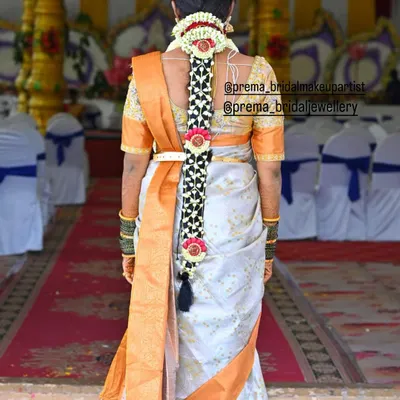 A classic South Indian bridal braid, intricately woven and decorated with a traditional hair accessory. This hairstyle is elegant and timeless.