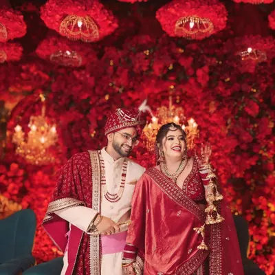 A stunning couple framed by a sea of red florals. I love using decor to create a grand, cinematic backdrop for wedding portraits that feel both epic and intimate.