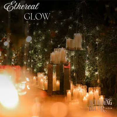 An aisle defined by an ethereal glow. We used hundreds of candles in glass hurricanes, placed on mirrored platforms to multiply their light and create a truly magical, shimmering effect.