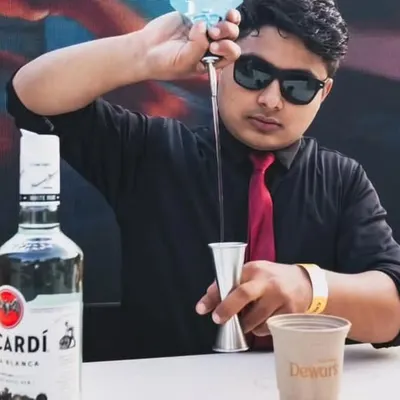 A close-up of one of our mixologists precisely measuring ingredients for a cocktail. This focus on accuracy and quality spirits like Dewar's and Bacardi is what makes our drinks consistently delicious.