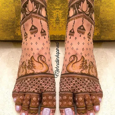 Your bridal look is complete with beautiful feet mehndi. This elegant design features graceful swans and delicate jhumka motifs, ensuring you look perfect from head to toe.