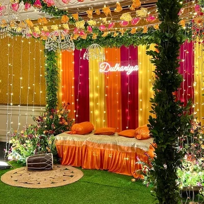 A vibrant Dholki night setup in a client's home. We used a colorful backdrop, fairy lights, a 'Dulhaniya' neon sign, and traditional elements like a dholki drum to create a fun and festive atmosphere.