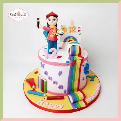 A masterpiece for a young artist! This colorful cake features a fondant artist figurine, edible paint tubes, and a rainbow cascading down the side, perfect for a creative and vibrant 12th birthday.