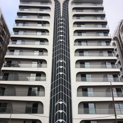 A detailed view of the completed facade at Rajhans Cremona. The central spine features a delicate, string-like pattern, reinforcing the violin-inspired theme and adding a layer of intricate detail to the building's exterior.