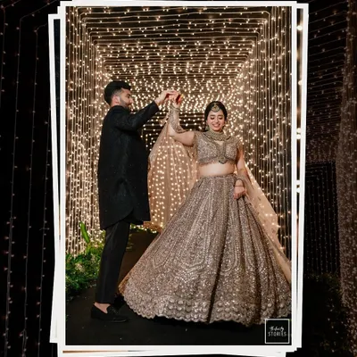 Dancing under a tunnel of fairy lights. This magical shot captures the couple in their own world, twirling during their reception, creating a moment that is both grand and intimate.