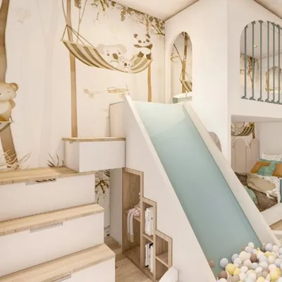This toddler's room is the ultimate indoor playground. I designed a custom loft bed structure that includes stairs with built-in storage, a slide, and a ball pit, all tied together with a charming woodland animal theme.