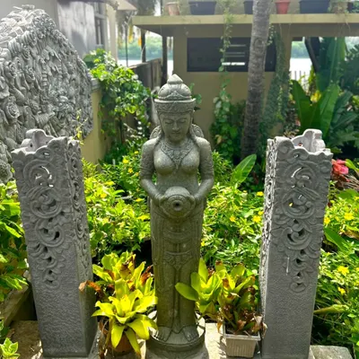 A client in Udupi, Karnataka, has created a beautiful garden sanctuary. Our Balinese doll statue stands gracefully between two carved stone lamps, surrounded by lush greenery.