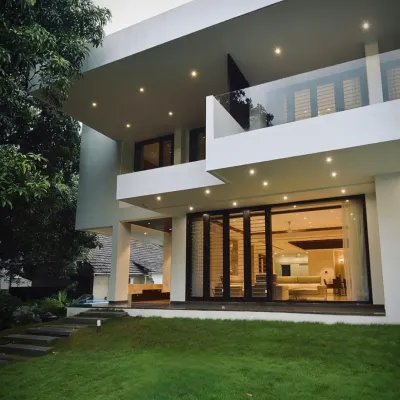 This home's facade features floating edges and expansive glass doors that open onto a lush lawn, blurring the boundary between the living room and the garden. The design creates a dialogue between the structure and the elements.