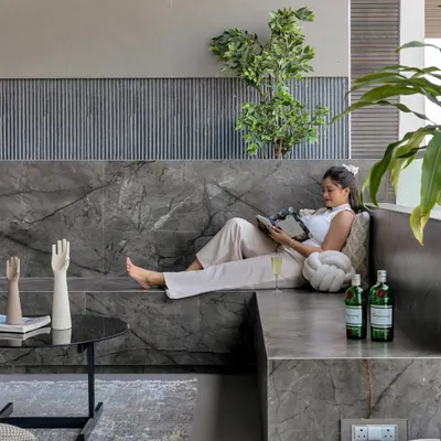 This deck is a perfect spot for a morning coffee or an evening drink. The built-in marble seating is softened with plush cushions and a rug, creating a sophisticated outdoor lounge with a stunning city view.