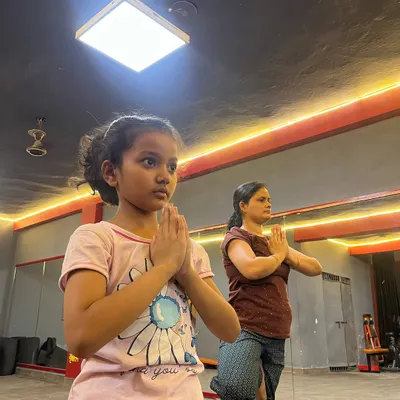 A young student learning Vrikshasana (Tree Pose). Starting yoga early is a wonderful way to build balance, focus, and body awareness.