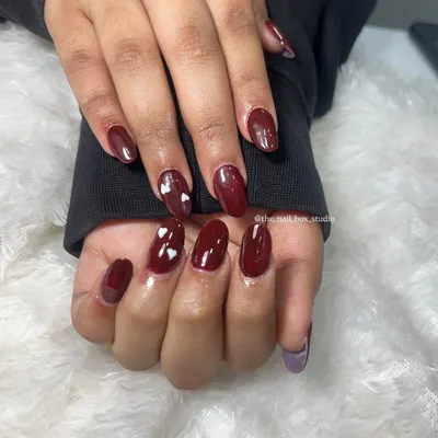 A beautiful and simple set of acrylic extensions with a deep, glossy maroon gel polish. I added a few tiny, hand-painted white hearts for a sweet and subtle touch of art.