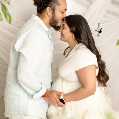 For me, a photo has to feel like a journey of the heart. This simple, intimate moment, a kiss on the forehead, speaks volumes about the love and anticipation that fills this special time. It’s about capturing the bond.