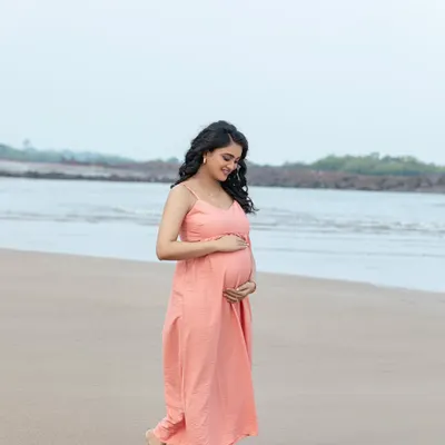 A peaceful walk along the shoreline. The soft, natural light and gentle sea breeze create a serene and beautiful setting for a maternity portrait.