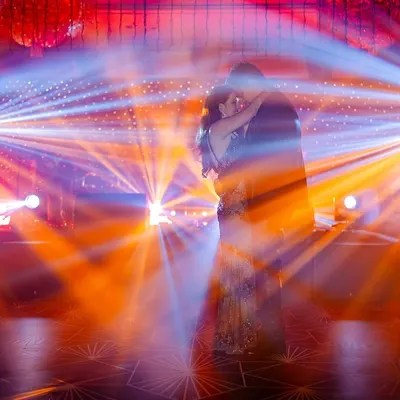 A silhouette of the couple dancing, surrounded by dramatic stage lights. This is a shot that screams 'cinematic'.