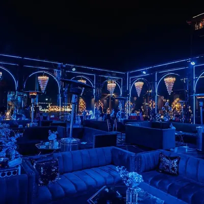 We turned this Sangeet into a high-end, moody lounge with deep blue lighting, plush velvet sofas, and dramatic chandeliers. It's all about creating a vibe.