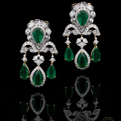 A statement jewel is your voice before you even speak. These emerald and diamond chandelier earrings are crafted for women who command a room. The design features pear-shaped Zambian emeralds surrounded by a halo of brilliant diamonds, creating an aura of undeniable elegance.
