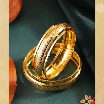 Wrapped in tradition, shining with love. These broad gold kadas feature a detailed etched pattern, making them a timeless and substantial piece for bridal or festive wear.