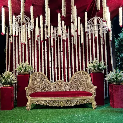 A traditional Godh Baarai (baby shower) setup. We used a rich red and white theme with an ornate sofa and hanging tuberose garlands to create a royal and classic look for the mommy-to-be.
