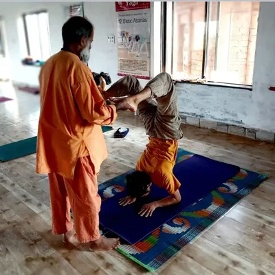 Personal attention is key for progress in advanced Hatha Yoga. I guide each student through complex postures like this supported scorpion pose to build confidence and ensure safe advancement in their physical practice.