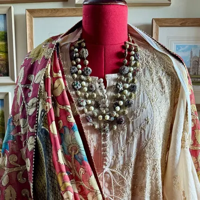 A styled view of our Chikankari tissue chanderi Achkan Anarkali. The ensemble is completed with a hand-painted Srikalahasti Kalamkari dupatta featuring majestic peacock motifs, creating a look of timeless elegance.