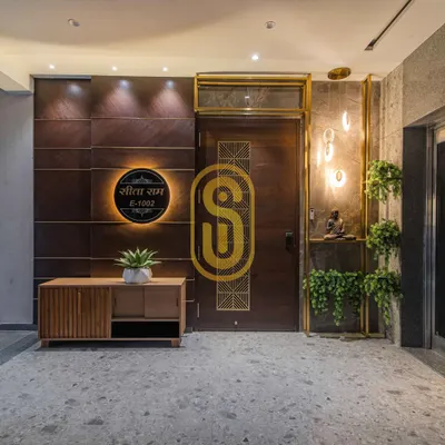 A view of the grand entrance foyer under different lighting, highlighting the warm spotlights on the wood-paneled wall. This shows how lighting design can change the mood of a space.