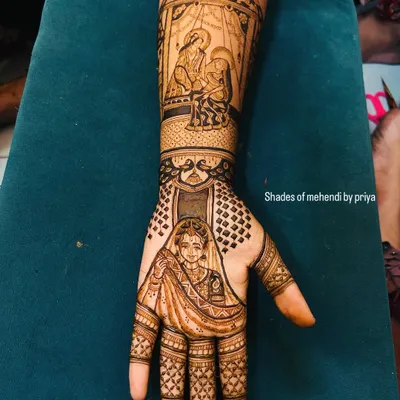 A full bridal arm telling a story. This design includes a bride portrait on the hand and a detailed doli scene on the forearm, capturing the emotion of the wedding day.