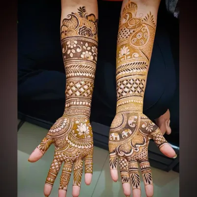 This design prominently features a peacock on the forearm, a classic symbol of beauty and royalty in bridal mehandi.