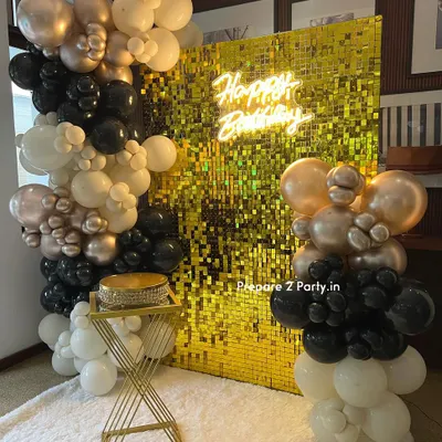 Our gold sequin shimmer wall provides the ultimate glamorous backdrop for any celebration. Here, we've paired it with a 'Happy Birthday' neon sign and an organic balloon garland in black, white, and chrome gold for a chic and modern party look.