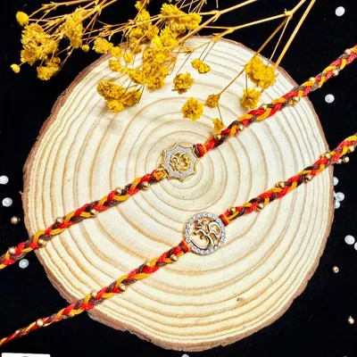 A simple and spiritual 'Om' rakhi. Hand-braided with colorful threads and accented with gold beads, this design is perfect for a brother who appreciates subtlety and meaning.