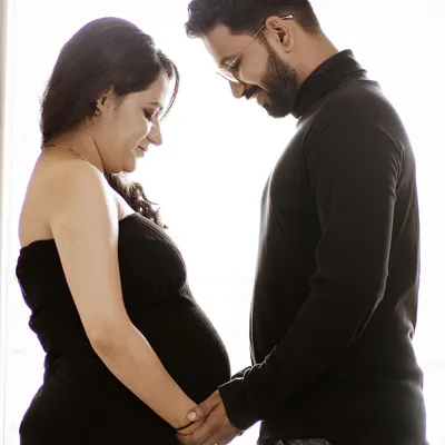 A high-contrast, minimalist silhouette shot of a couple. This modern style creates a powerful and intimate image, focusing on the shape and connection between the parents-to-be.