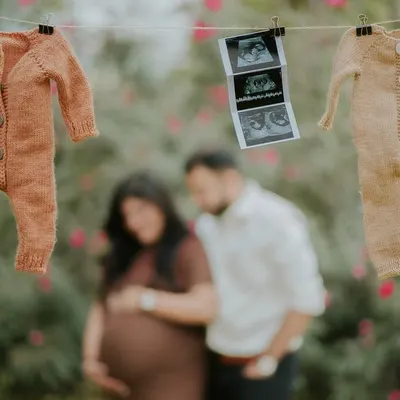 The first sneak peek. This creative announcement shot uses a clothesline with baby outfits and the first ultrasound picture to share the exciting news.