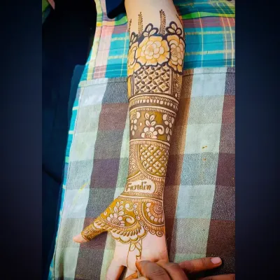 A close-up of a bridal design featuring bold, beautiful flowers on the forearm. The shading technique makes the petals stand out.