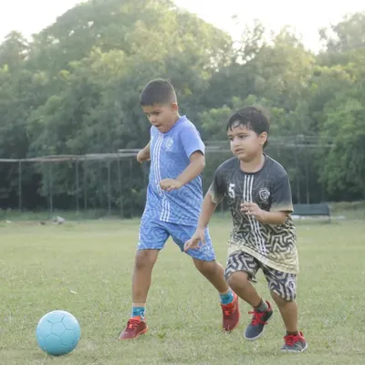 Two young players focused on the ball during a friendly match. Our games are all about participation and giving every child the chance to be part of the action.