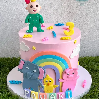 This Cocomelon cake is perfect for a toddler's birthday, featuring JJ and his animal friends. The design includes a bright rainbow and other fun, handmade fondant characters on a delicious pink whipped cream cake.