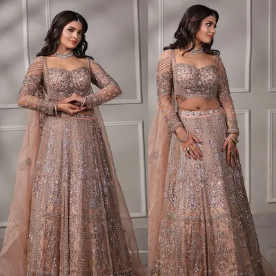 A full view of this stunning engagement bride in her pastel peach lehenga. The soft waves in her hair and the glowing makeup create a dreamy, romantic look.