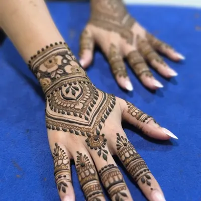 A clean and modern Arabic design. This style focuses on the back of the hand with a central motif and detailed finger work, leaving parts of the skin bare.