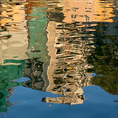 This isn't a painting. It's a photograph of a reflection, where the moving water turns a simple scene into a piece of abstract art.