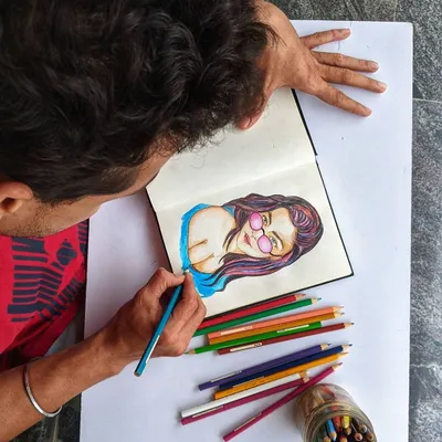 Here I am working on a colorful portrait with colored pencils. This behind-the-scenes view shows the focus and care that goes into every illustration.