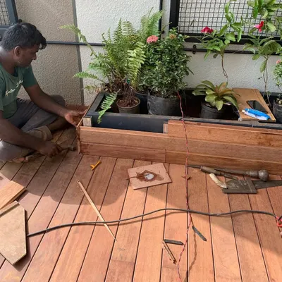 Here you can see the detailed craftsmanship involved in building a custom wooden planter and deck for a high-rise terrace.