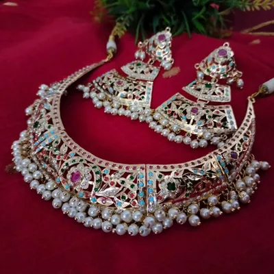 The 'सुहानी' (Suhani) necklace set is a masterpiece of Jadau work. This grand choker features intricate multi-coloured stones and pearls, perfect for a bride or for making a royal statement at any grand occasion.