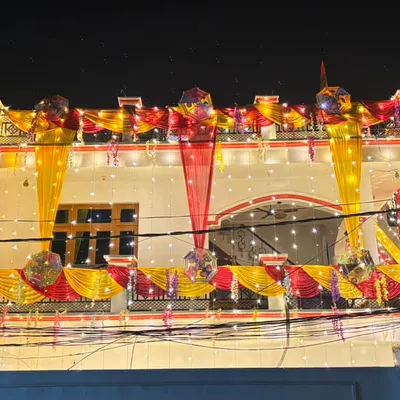 A night view of a fully decorated wedding house. I use a combination of yellow and red drapes with fairy lights to make the entire building shine and stand out in the neighbourhood.