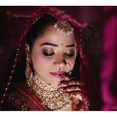 A stunning close-up bridal portrait with dramatic lighting. We focus on capturing the beauty of the bride's makeup, jewelry, and expression under a veil.