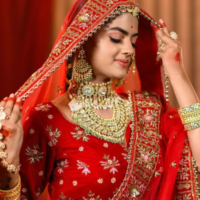 A close-up of our Padmavati look, focusing on the elaborate layered necklaces and the sheer red dupatta. We ensure every piece of jewelry is perfectly selected to match the character's iconic style.